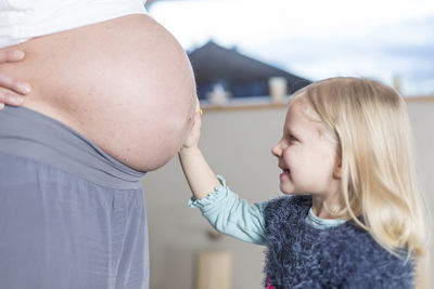 Side view of girl with pregnant mother