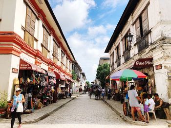 People on street amidst buildings in city