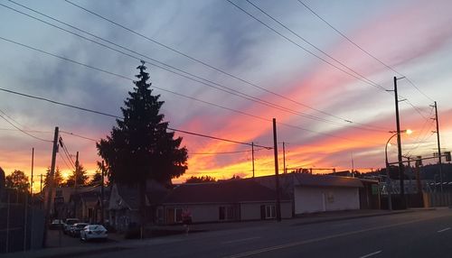 Cars on road against sky during sunset