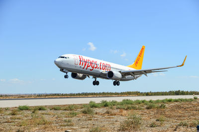 Low angle view of airplane flying against blue sky