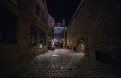 Narrow street amidst buildings in town at night