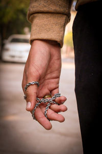 Cropped hand of man holding chain