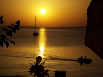 Silhouette of people in boat against clear sky during sunset