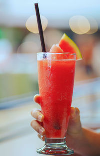 Glass of delicious healthy watermelon juice in young female hands. healthy drink concept.