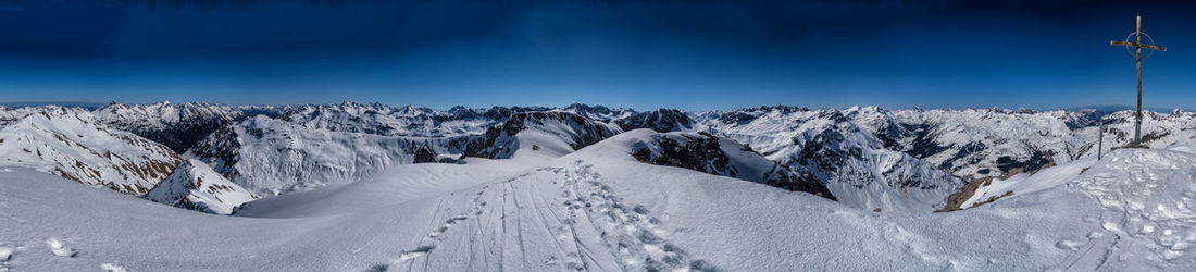 Panoramic view of snowcapped mountains against blue sky