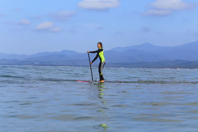 Female sup surfer on a wave