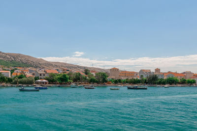 Scenic view of sea by buildings against sky