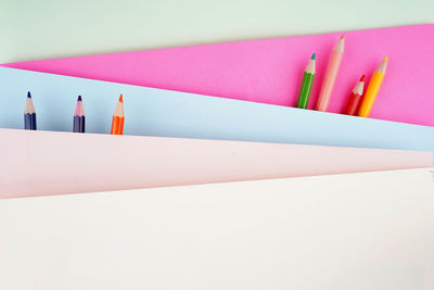 High angle view of colored pencils against white background