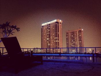 Modern buildings against sky at night