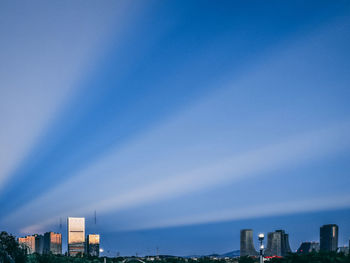 Modern buildings in city against blue sky