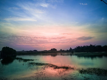 Scenic view of lake against sky at sunset