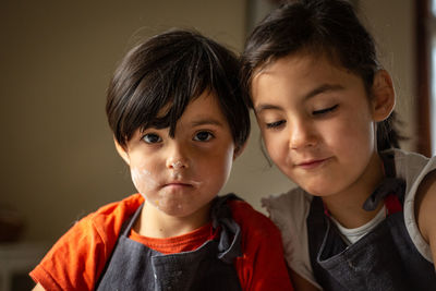 Portrait of two girls with faces dirty with flour