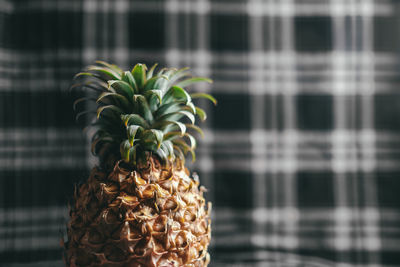 Close-up of pineapple against chequred fabric background