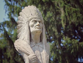 Close-up of angel statue against trees