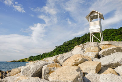 Rock formation by sea against sky