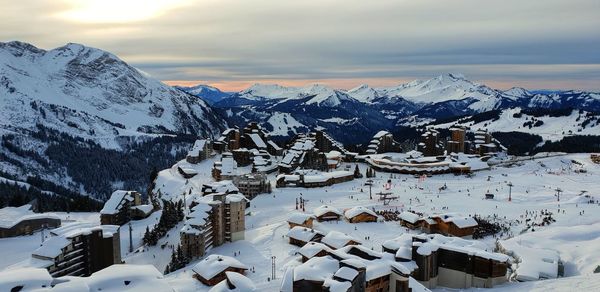 Snow covered houses and mountains against sky at ski resort in france