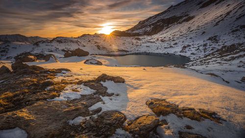 Scenic view of snow covered mountains against sky during sunset