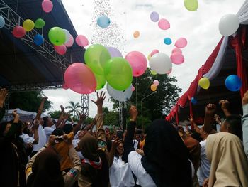 People celebrating with colorful balloons at street