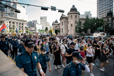 People on street against buildings in city