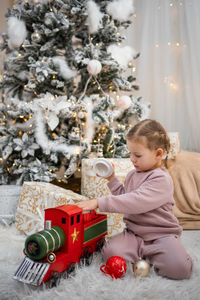 Cute girl playing with christmas tree