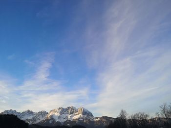 Scenic view of snowcapped mountains against blue sky