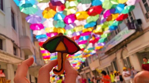 Close-up of hand holding multi colored umbrella