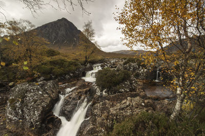 Scenic view of waterfall against sky