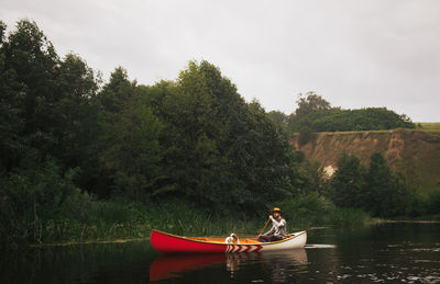 Man in canoe with his dog in a beatiful nature park on the river