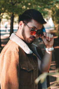 Young man wearing sunglasses while standing outdoors