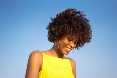 Portrait of a young black woman wearing yellow dress smiling