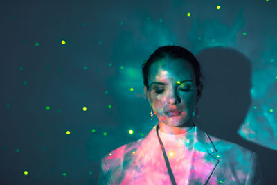 Portrait of young woman in illuminated light