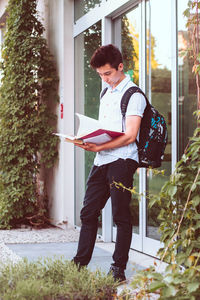 Full length of young university student standing at door