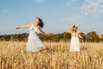 Woman standing on field against sky