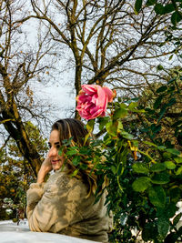 Woman holding flower on tree