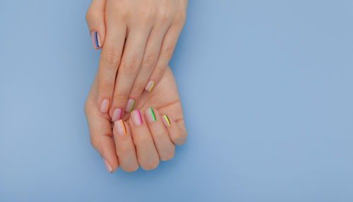 Close-up of woman hand against blue background