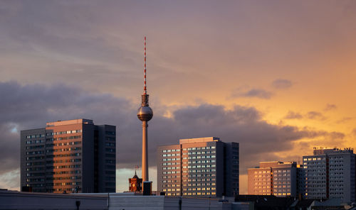 Modern buildings in city against sky during sunset