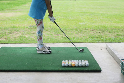 Low section of girl playing golf at course