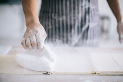 Midsection of chef using flour to make noodles