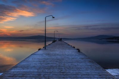 Pier over sea against sky during sunset