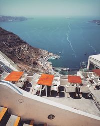 High angle view of chairs by sea