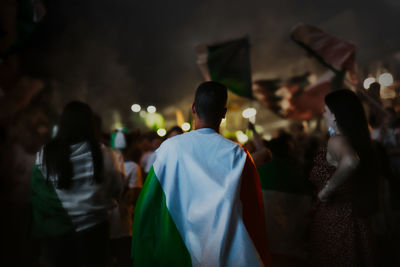 Rear view of people standing against blurred background