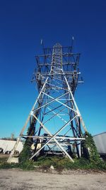 Low angle view of ferris wheel against clear blue sky