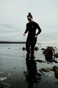 Portrait of young man standing in sea against sky