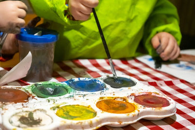 Midsection of man holding multi colored candies on table