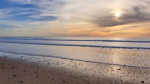 Scenic view of beach against sky during sunset