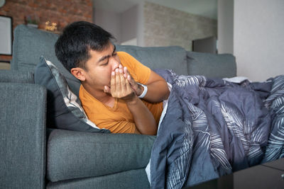 Man sitting on sofa at home