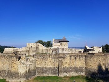 Low angle view of historic building against blue sky