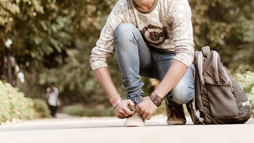 Midsection of man sitting on road