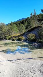 Scenic view of lake against clear blue sky