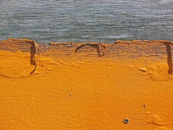 Yellow paint peeling off from wooden plank